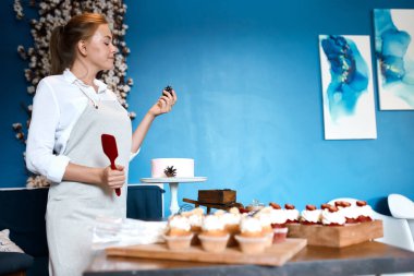 Genç yetenekli aşçı, çam kozalağını kontrol ediyor.