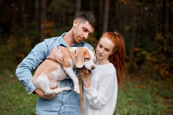 Красивый мужчина держит свою собаку, представляет ее своей девушке — стоковое фото