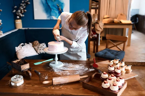 hardworking young woman enjoying decorating cake