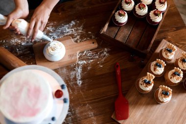 Kadın öğrencilere tatlıyı süslemeyi öğretiyor.