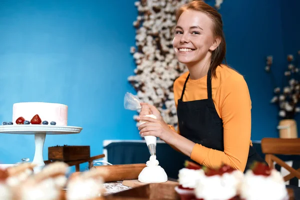 Encantador chef alegre obtiene placer de cocinar cupcakes — Foto de Stock