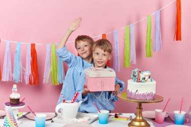 İki sarışın çocuk en iyi arkadaşlarına hediye olarak bir kutu verecek.