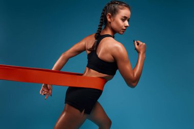 Harika bir kız pilates eğitimi sırasında bant esnetiyor.