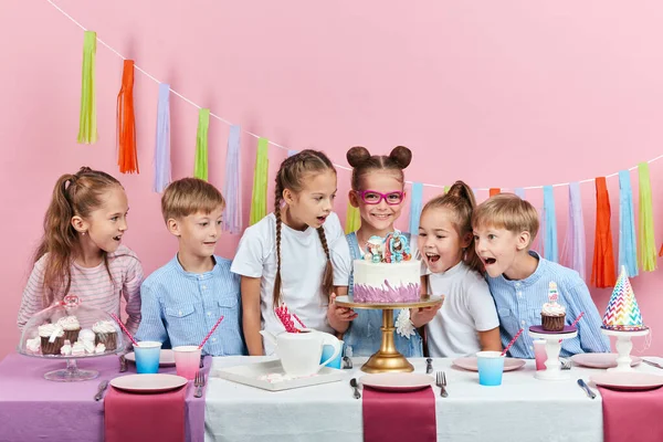 Group of children being surprised, shocked with beautiful cake