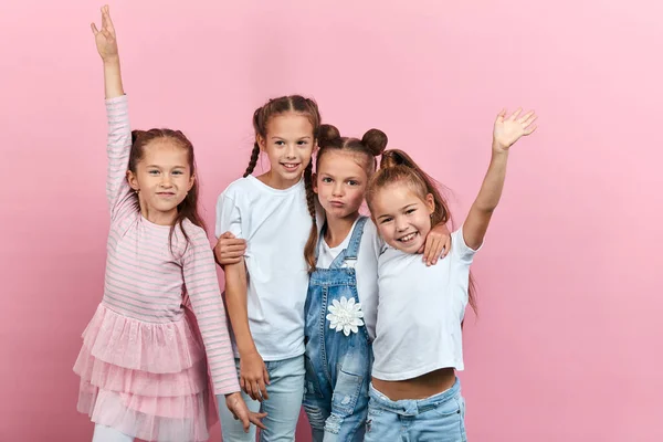 Entzückende kleine Mädchen haben Spaß isoliert auf rosa Hintergrund — Stockfoto