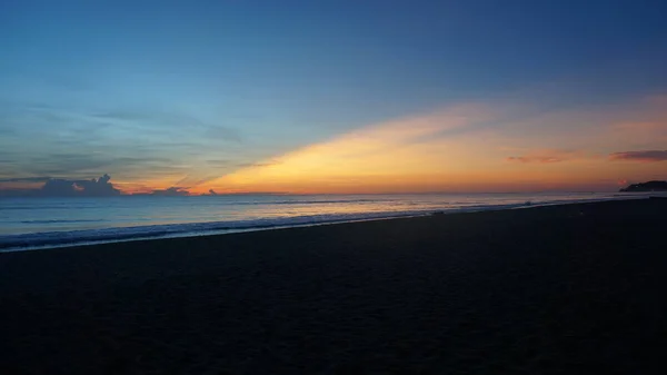 Matahari terbit dengan warna hangat, biru dan ungu litghts mencerminkan dalam gelombang — Stok Foto