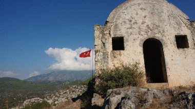 Türk bayrağı hayalet şehir Kayaköy uçan. Fethiye, Türkiye.