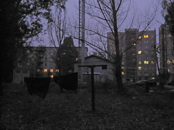 Παλιό βρώμικο πρόσοψη κτήριο κατοικιών, πολυόροφο σπίτι, Σοβιετική αρχιτεκτονική. το βράδυ, το βράδυ, με κρεμασμένα ρούχα για να στεγνώσει μπροστά — Φωτογραφία Αρχείου