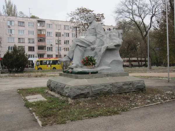 Simferopol kırmızı çiçeklerle beyaz lenin anıt figürü heykeli oturan — Stok fotoğraf