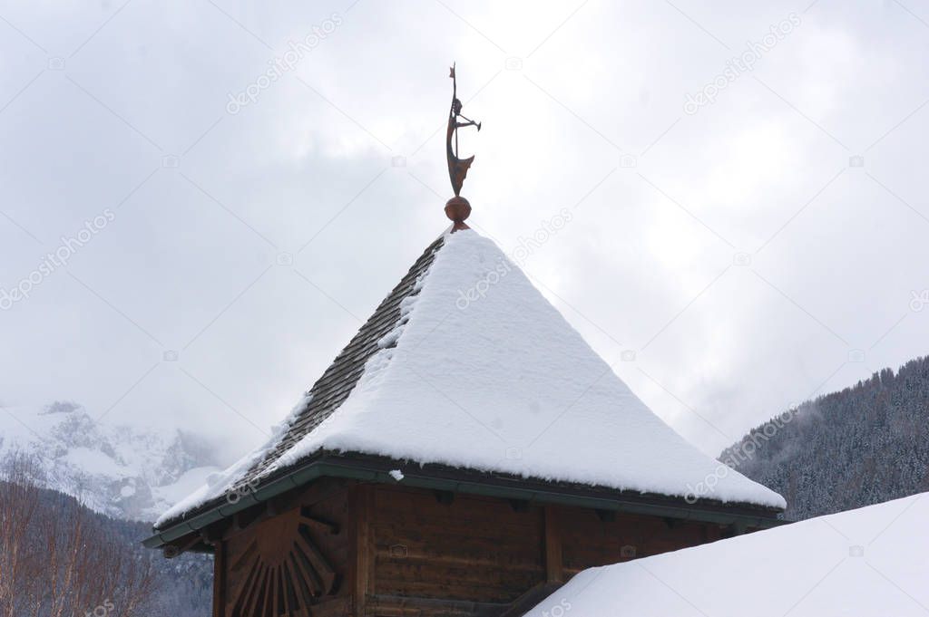 Angel sculpture statue on top of a traditional building in south tyrol, dolomites