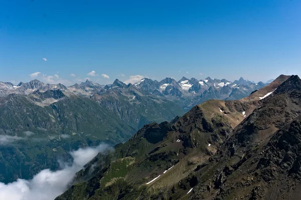 Panorama av den kaukasiska åsen och Elbrus sedd från en topp nära Dombay, 2019 — Stockfoto