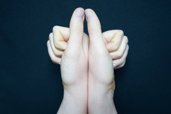 Isolated woman hand closeup making gestures on black background