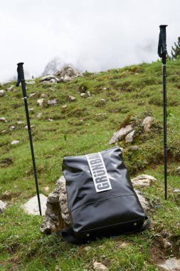 Yürüyüş, yürüyüş, şehir sırt çantası ve doğa dışında baston taşıyan siyah bir sırt çantası.