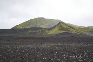 İzlanda 'nın dağlık bölgelerindeki volkanik manzara, yeşil yosunlu siyah kül çölleri.
