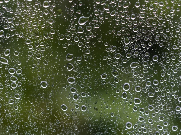 Água cai fundo. Gotas de água no vidro da janela. Quedas de chuva — Fotografia de Stock