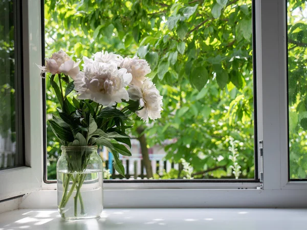 Pencere kenarındaki vazoda çiçekler. 