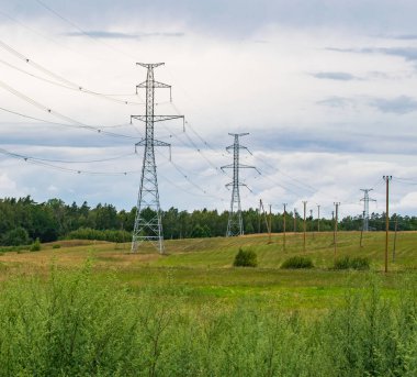Yüksek voltajlı elektrik hatları mavi gökyüzü bulutlu destekler. Elektrik Sanayi.