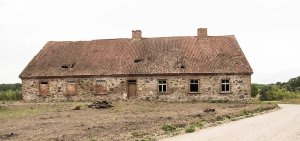 Starý opuštěný kamenný dům s taškovou střechu ve vesnici. — Stock fotografie