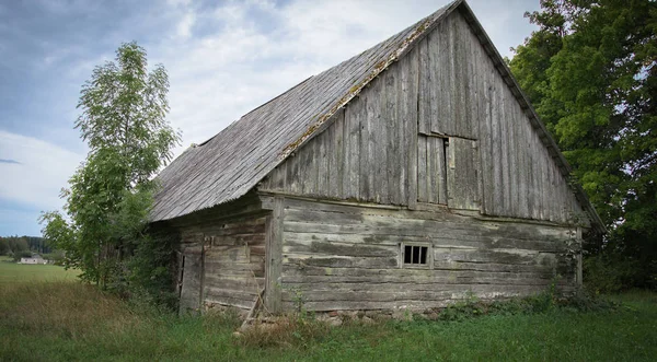 Staré opuštěné dřevěné kůlny s střešní břidlice v obci — Stock fotografie