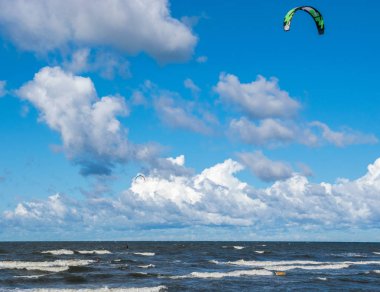 Kitesurfing. Kiteboarding eylem fotoğrafları. Erkek dalgalar arasında hızlı bir şekilde gider.