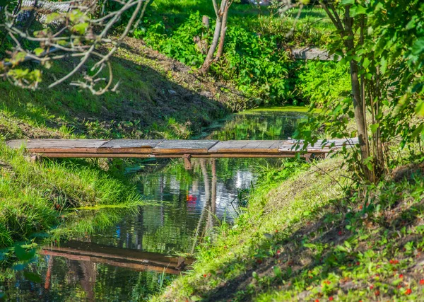 Uma ponte de madeira caseira áspera através de uma vala na aldeia de férias . — Fotografia de Stock