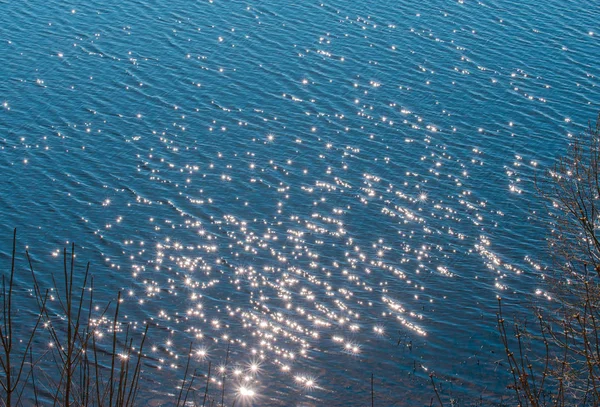 Reflection of the sun on the water surface. Blue background. — Stock Photo, Image