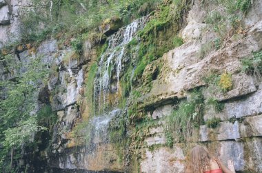 Sonbahar tepelerinde gri kaygan çağlayan gri kayalardan düşen sığ dere parlak beyaz şelale