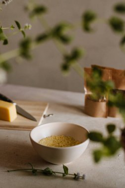 Mutfaktaki peynirli, baharatlı ve nane yapraklı kuskus lapalı oldukça küçük bir fildişi kâse. Lezzetli ve sağlıklı vejetaryen yemekleri kırsal tarzda izole edilmiş.