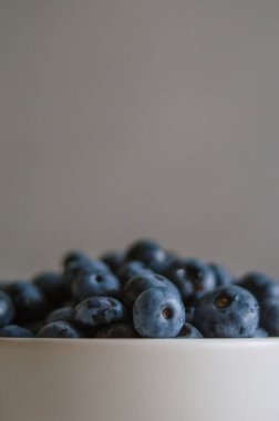 Fildişi kasede taze yaban mersinli koyu bir makro. Sağlıklı beslenme ve beslenme kavramı. Antioksidan organik süper yiyecekler.