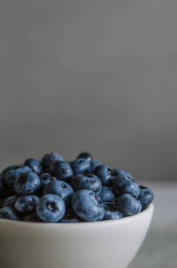 Fildişi kasede taze yaban mersinli koyu bir makro. Sağlıklı beslenme ve beslenme kavramı. Antioksidan organik süper yiyecekler.