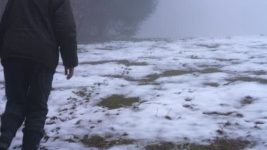 Tepeye gider ve kar izlemeler tarafından sis yürüyen adam