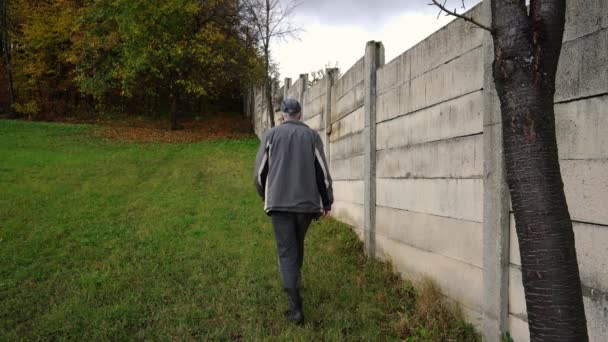 Homem Vai Longo Cerca Concreto Floresta Outono — Vídeo de Stock