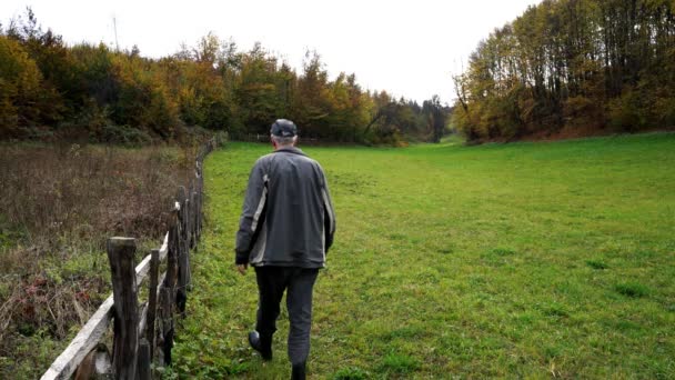 Mann Fährt Altem Holzzaun Entlang — Stockvideo