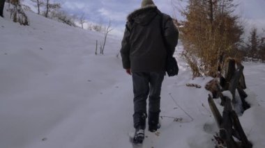Adam dokunur ve karda eski ahşap çit boyunca gider