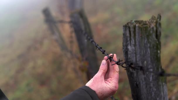 Uomo Tocca Recinzione Filo Nella Nebbia — Video Stock