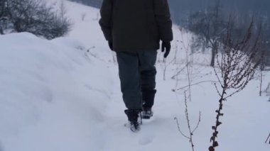 Adam derin karda kuru çiçekler geçer