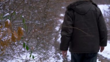 Erkek karlı orman yolundan gider