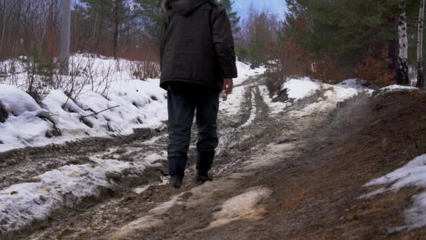 Чоловік Проходить Через Мокрий Лісовий Шлях Тане Сніг — стокове відео