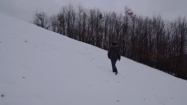 Uomo Che Cammina Sulla Collina Nella Neve — Video Stock
