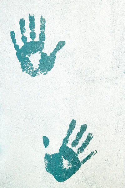 Handprints on the plastered wall.