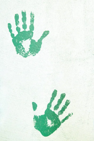 Handprints on the plastered wall.