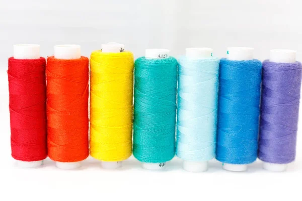 A row of spools of thread. rainbow colors — Stock Photo, Image