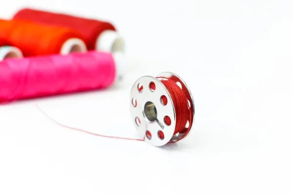 Sewing bobbin and row of spools of thread — Stock Photo, Image