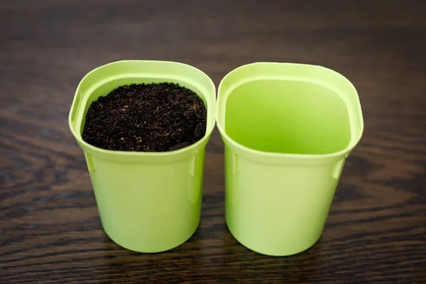 The concept is empty and full. Two flower pots, one with the ground, the second empty. — Stock Photo, Image
