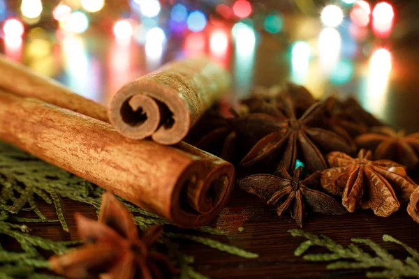 Anise and cinnamon sticks on a wooden table with colorful highlight. selective focus. Background for new year greeting card — Stock Photo, Image