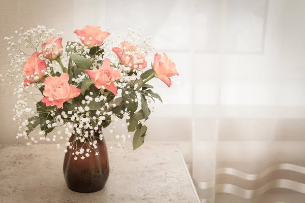 A bouquet of delicate roses stands in a clay vase on the table — Stock Photo, Image