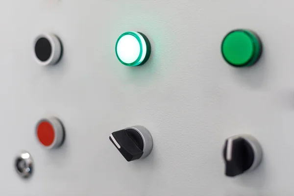 Сіра панель з червоними і кількома зеленими кнопками і чорними перемикачами — стокове фото