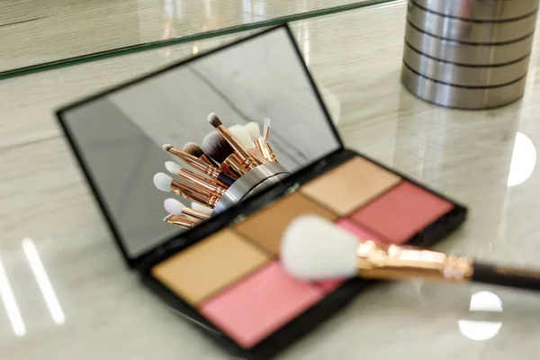 Pinceles de maquillaje se reflejan en un espejo de paleta con sombras — Foto de Stock