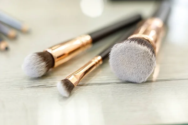 Un conjunto de pinceles para el maquillaje se encuentra sobre la mesa en el salón de belleza — Foto de Stock