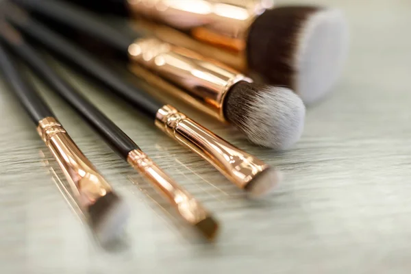 Un conjunto de pinceles para el maquillaje se encuentra sobre la mesa en el salón de belleza — Foto de Stock